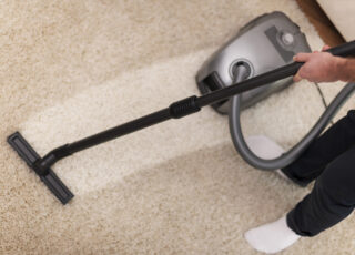 Homem realizando limpeza profissional de carpetes para aumentar a durabilidade das fibras